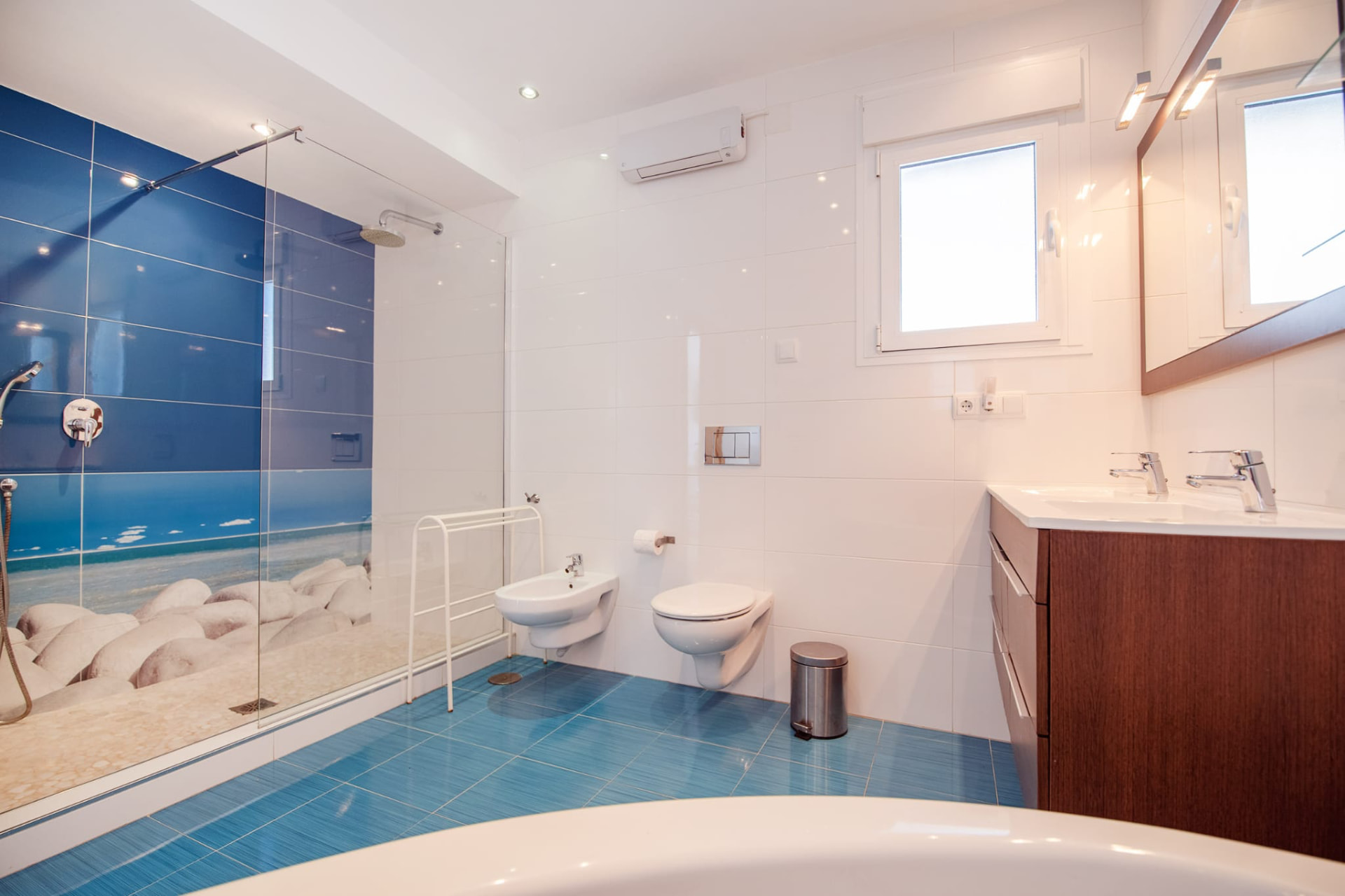 Badezimmer mit Dusche und blauen Fliesen